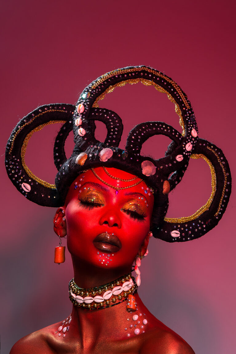ÒRÌSÀ OSUN (Oshun) 
In this image, we created a real-life version of the drawings based on the Yoruba deity known as "ÒRÌSÀ" using practical makeup from the headpiece to the red paint on her skin. She is the goddess of fertility and sensuality.