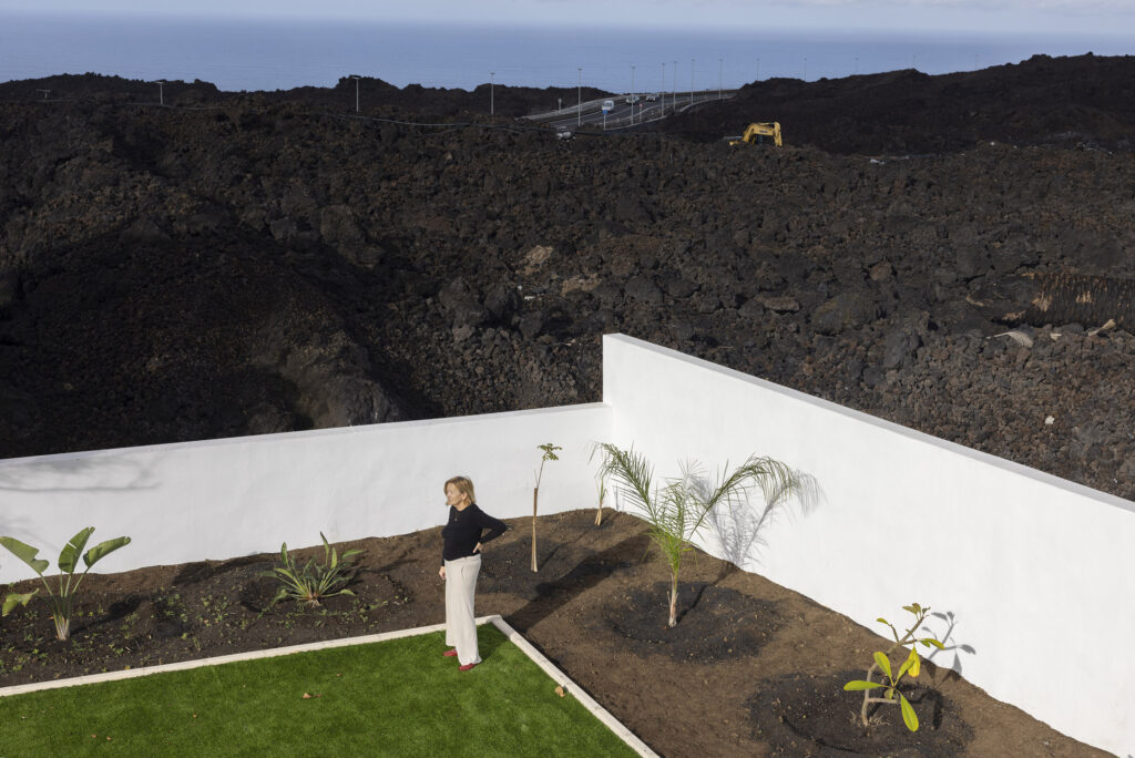 Canu Martin-Mur,  (67)  from Spain. She had to remove some lava that broke her garden walls and destroyed mature palm trees. She has since replaced tha wall and laid down an artificial lawn and planted new palms and plants to regrow again. 

La Palma. An island of the Canaries. Two years after the Cumbre Vieja volcanic eruption in late 2021.  Photography taken on January 2024.